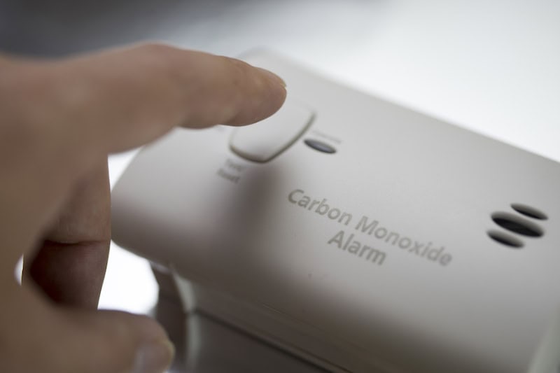 Homeowner testing carbon monoxide alarm.